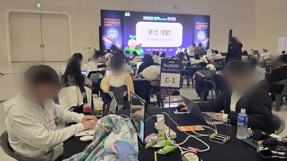본선 개발 안내 화면 아래 C-1 테이블에서 작업하는 팀원들