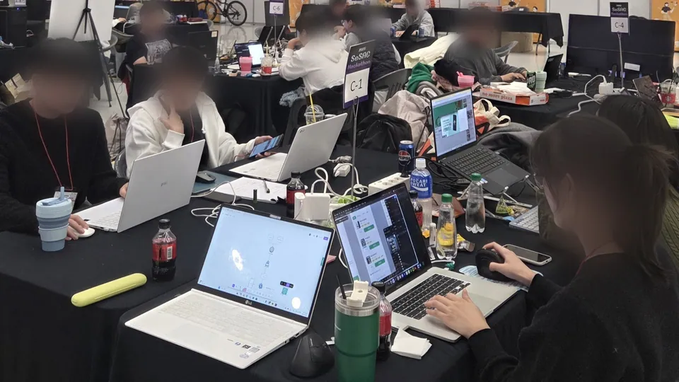 C-1 테이블에서 노트북으로 작업 중인 팀원들